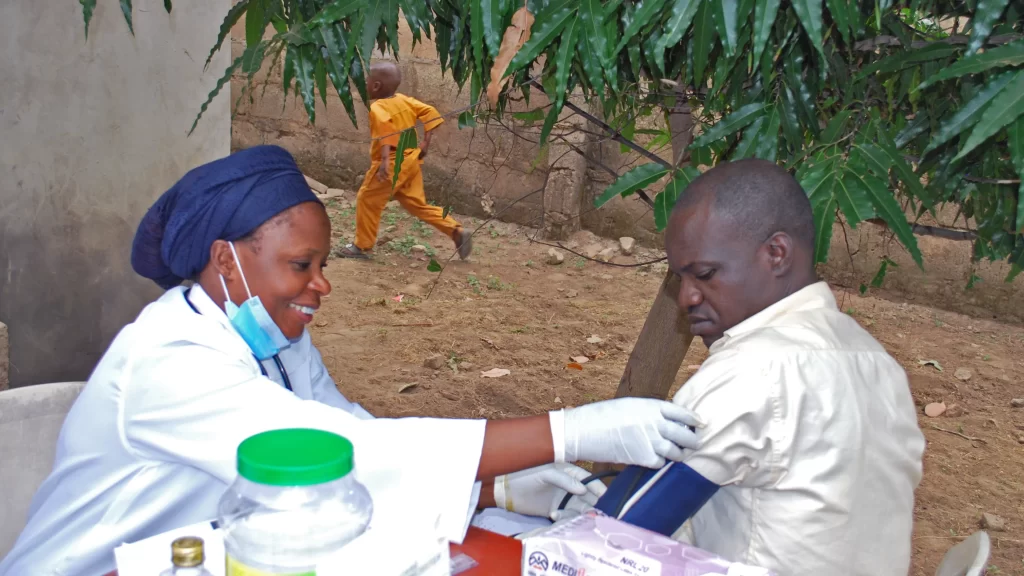 Photo of a nurse providing medical care in rural Nigeria.