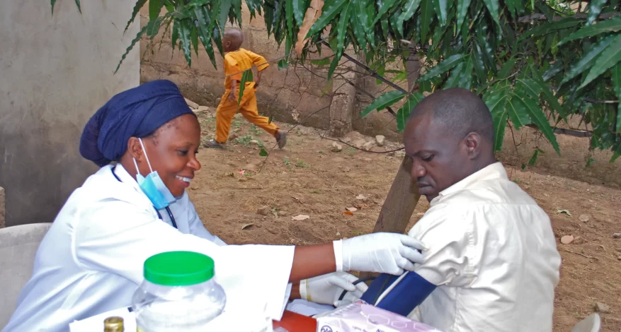 Photo of a nurse providing medical care in rural Nigeria.